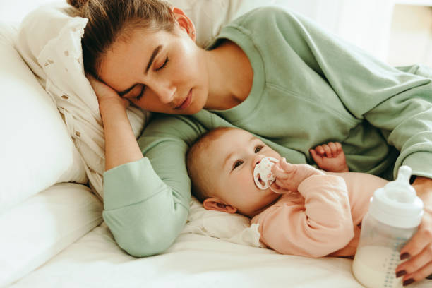 istock New mom taking a nap next to her baby 1367940898