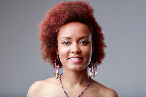 Attractive charismatic friendly young Black woman portrait in a head and shoulders smiling at the camera