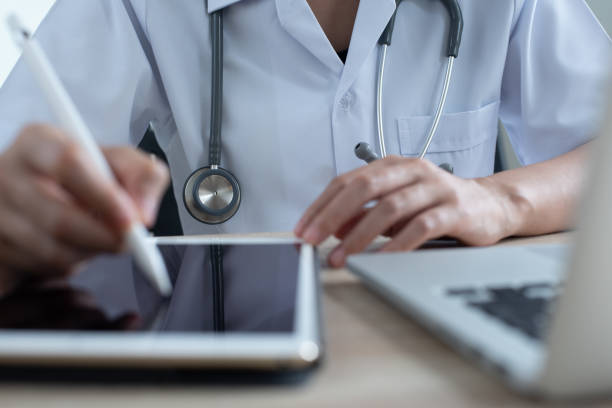 istock Doctor working on digital tablet and laptop computer in office 1367943432