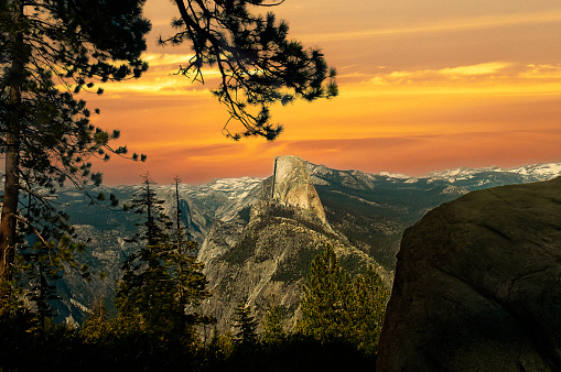 Half Dome from Glacier Point with an orange sunset sky in Yosemite National Park.