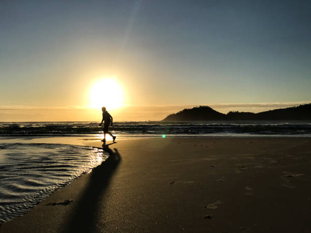 istock People at dawn and backlight walking on the beach 1367945213