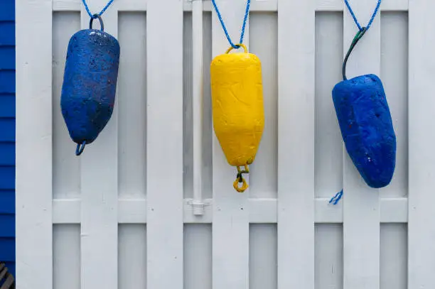 Photo of Colorful buoys hanging on a shed