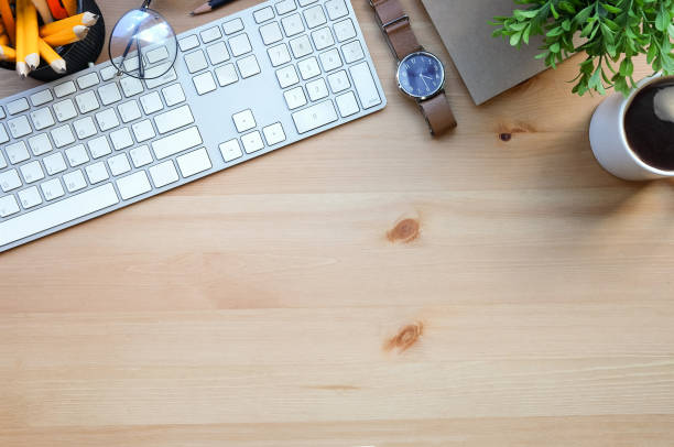 istock Top view wireless keyboard, coffee cup glasses, notebook and houseplant on wooden table. 1367949821