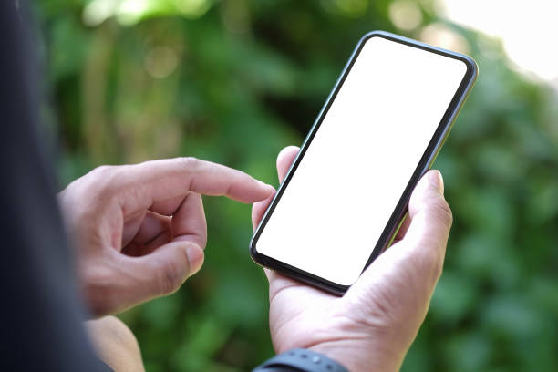 istock Close up view young man sitting in the park and using smart phone. 1367949860