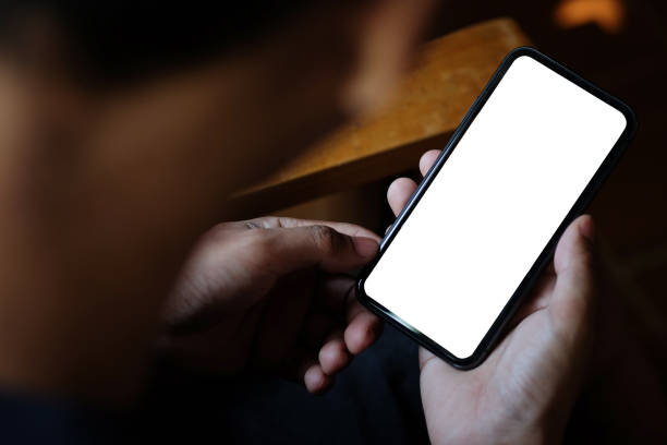 istock Young man sitting at his workplace and using smart phone. 1367949863