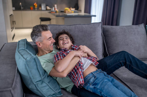 istock Happy father and son playing on sofa 1367953311