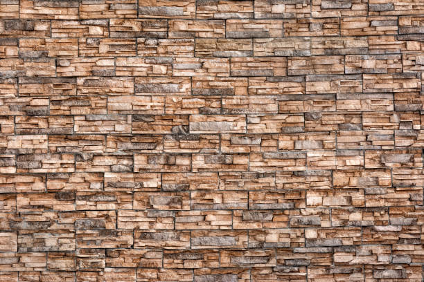 istock The wall is made of facing beige stone. 1367953398