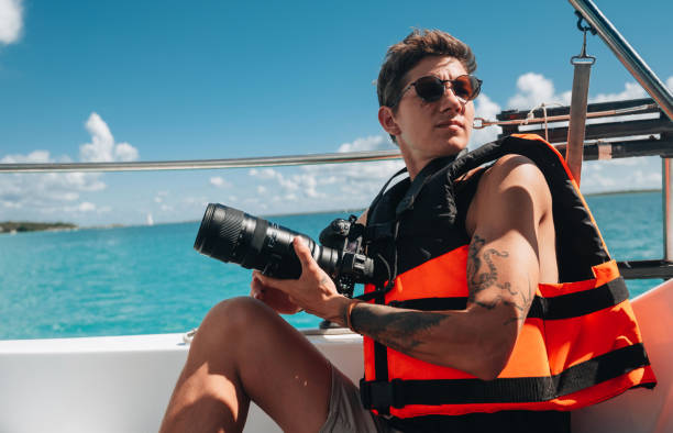 istock A young man photographer on a sailboat 1367954075