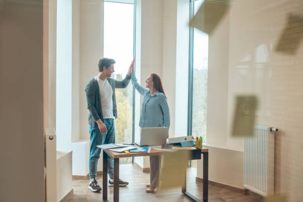 istock Man and woman standing with raised touching palms 1367954959