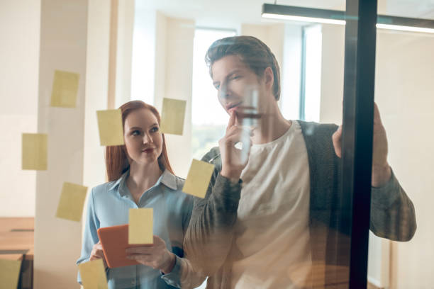 istock Woman looking at excited man thinking about project 1367954965