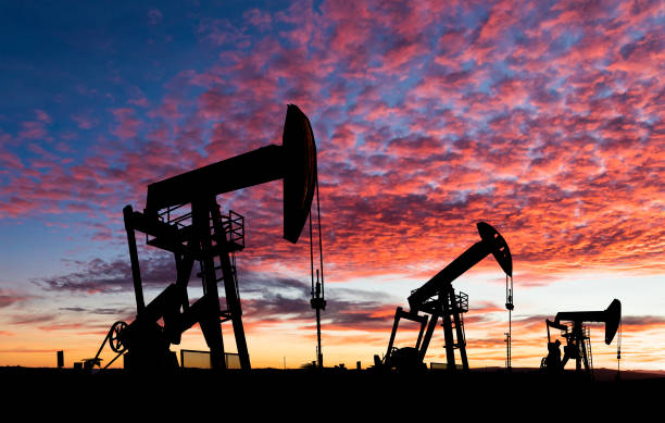 Oil pumpjacks in silhouette at sunset stock photo