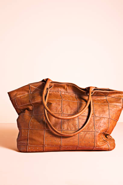 Fashionable leather bag isolated on pink background