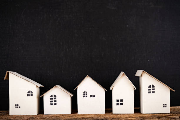 istock Small white houses in a row on a wooden table 1367957836