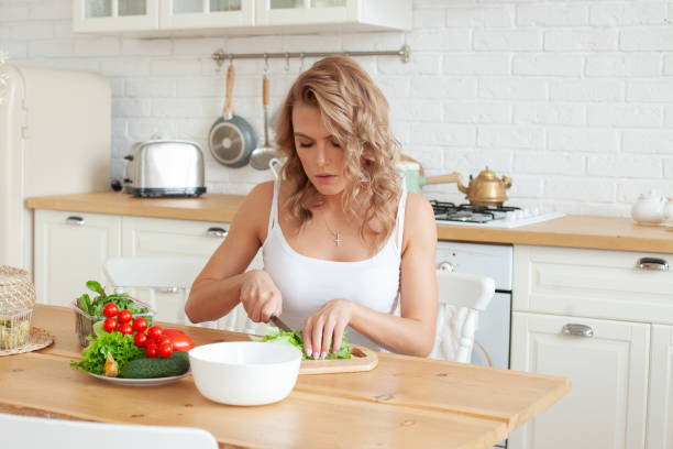 istock Attractive woman with vegetable in her kitchen. Healthy eating 1367958829