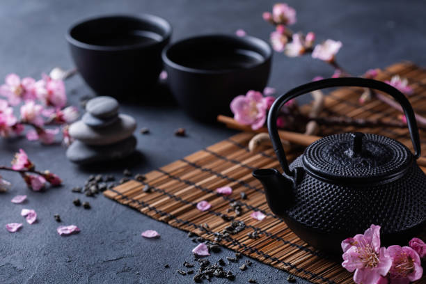 istock Teapot and tea cups with blooming almond tree branches 1367960679