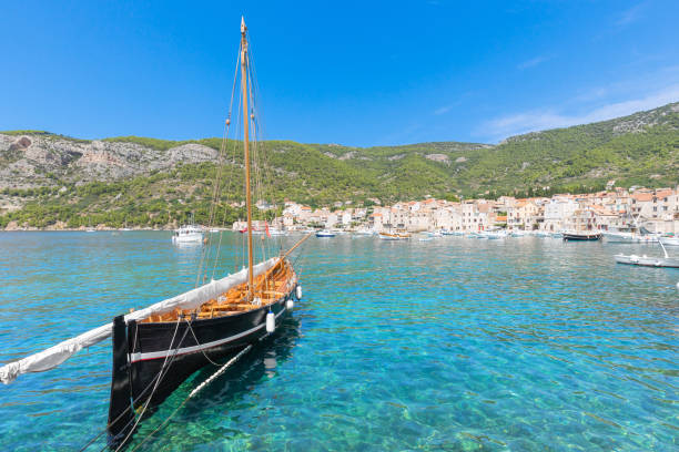 Beautiful wooden classic sail boat moored in Komiza Village harbor, Vis Island, Croatia