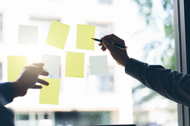 istock Business people meeting at office and use post it notes to share idea. Brainstorming concept. Sticky note on glass wall. 1367962071