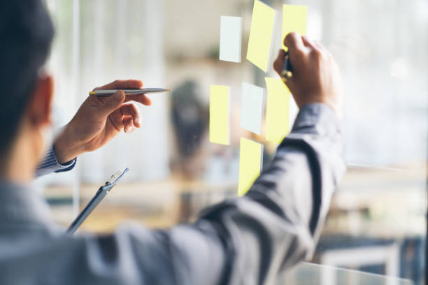istock Business people meeting at office and use post it notes to share idea. Brainstorming concept. Sticky note on glass wall. 1367962591
