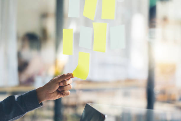 istock Business people meeting at office and use post it notes to share idea. Brainstorming concept. Sticky note on glass wall. 1367962816