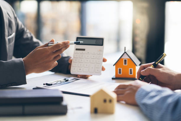 House model with agent and customer discussing for contract to buy, get insurance or loan real estate or property. House model with agent and customer discussing for contract to buy, get insurance or loan real estate or property. debts stock pictures, royalty-free photos & images