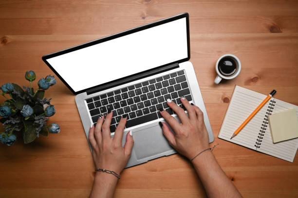istock Above view young woman using laptop computer on wooden desk. 1367966447