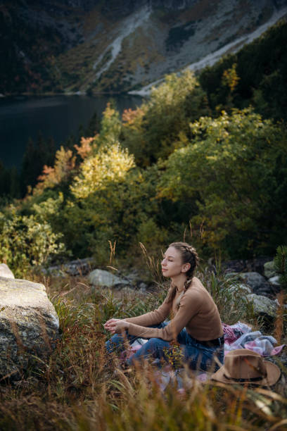 istock Young woman on a hiking trip sitting on a rock 1367969748
