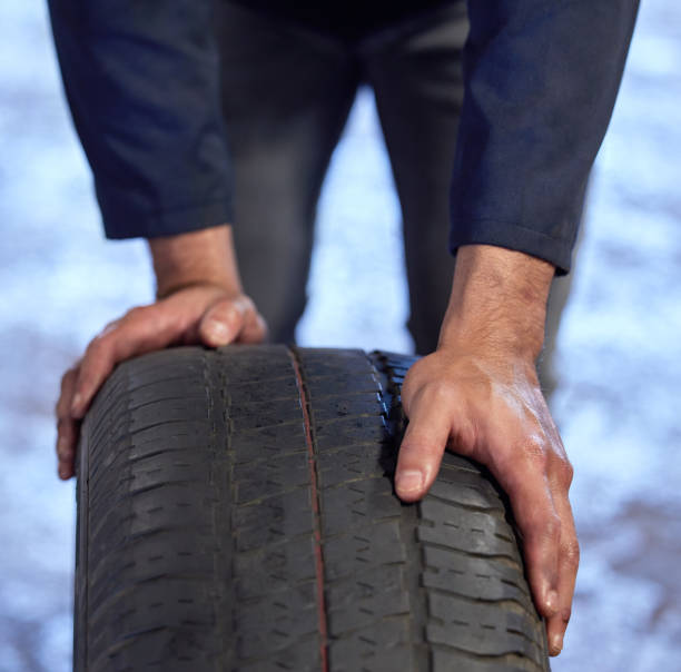 istock High angle shot of an unrecognizable male mechanic rolling a tyre through his workshop during a service 1367971084