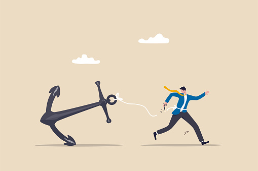 Freedom, relief or escape from bad habit, psychology anchoring effect or cut heavy burden to growing more concept, businessman using scissor to cut the rope tie himself with big heavy anchor.