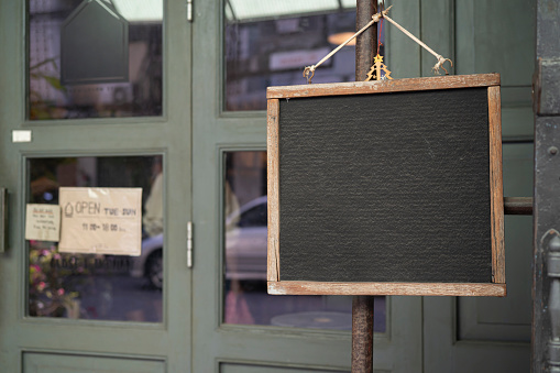 Empty black board hangs on an street's coffee shop. Street. Market. Copy space. Urban. Sale. Trading. Outdoor. Business