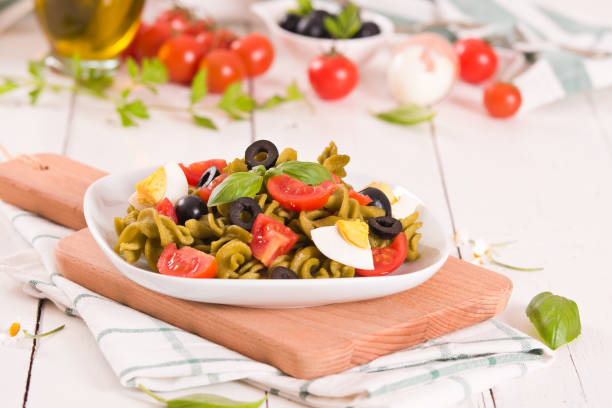 istock Fusilli pasta with cherry tomatoes, eggs and black olives. 1367974802