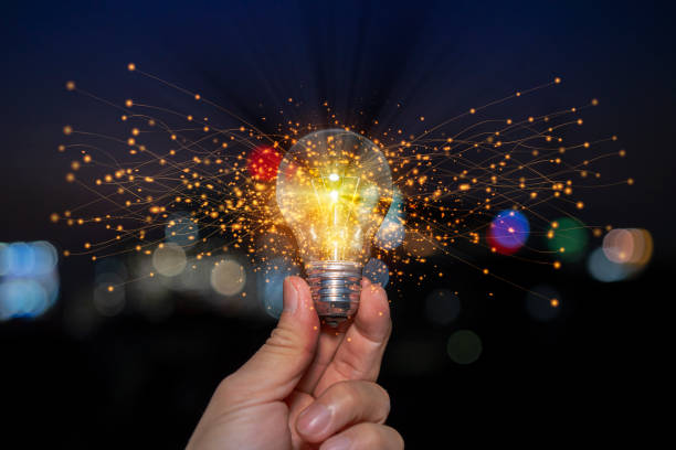 istock Hand holding light bulb glowing with orange light line and ray. 1367976762