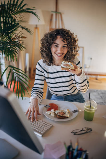 istock Woman eating breakfast in office 1367978197