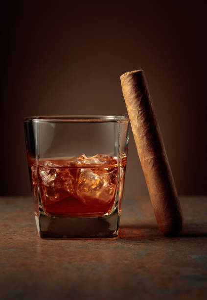 whiskey with ice and cigar on a rusty background. - cigar whisky bar cognac imagens e fotografias de stock