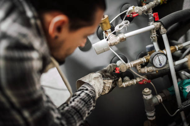 Heating engineer fixing modern heating system. Close up photo of a man fixing the pipes at home. gas stock pictures, royalty-free photos & images