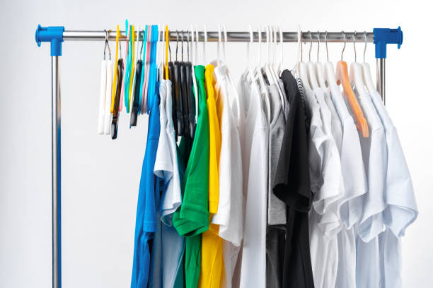 istock Clothes hang on clothing rack over white background. 1367982015