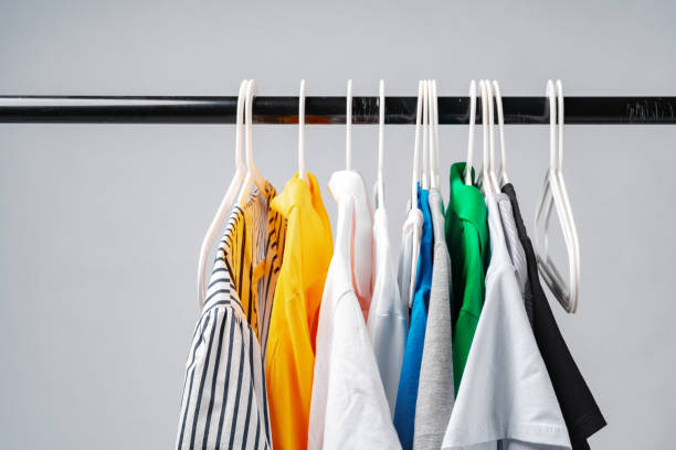 istock Clothes hang on clothing rack over white background. 1367983352