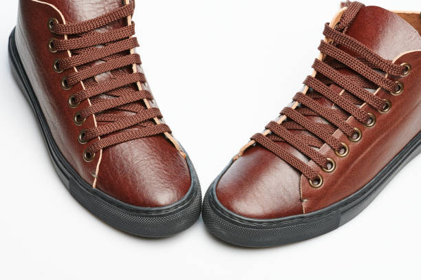 Original brown leather sneakers Original brown leather sneakers with laces isolated feet and condoms stock pictures, royalty-free photos & images
