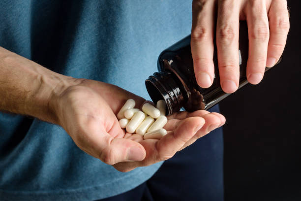 paume avec des capsules de suppléments sportifs en gros plan. - human hand science human muscle muscular build photos et images de collection