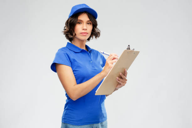 istock delivery girl with clipboard and pen writing 1367986932