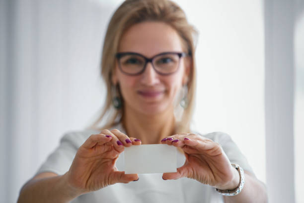 portrait of a dentist holding a business card. - glasses holding business card imagens e fotografias de stock