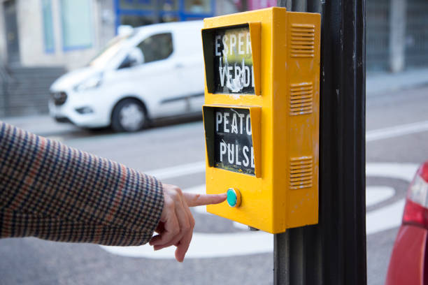 istock senior Caucasian woman's hand before pressing the yellow traffic light button with green button 1367989412