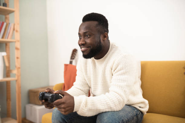 istock Young African American gaming and having fun at home 1367989708