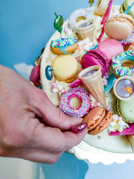 Close up Woman Hands Decorating Colorful Birthday Cake with Candle