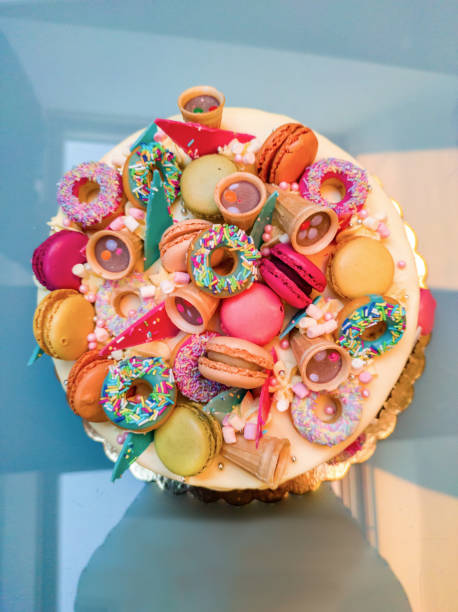 istock Beautiful Birthday Cake Decorated with Colorful Macarons, Donuts, Sprinkles,.... 1367989867