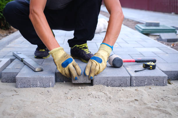 The master in yellow gloves lays paving stones stock photo