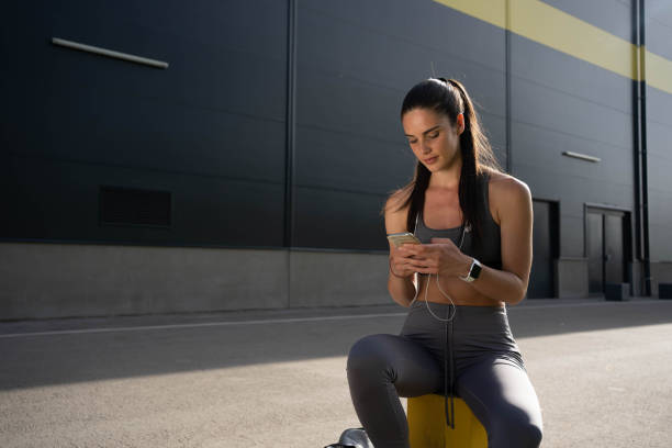 istock Active young woman suring the net on mobile phone while taking break from running 1367992324