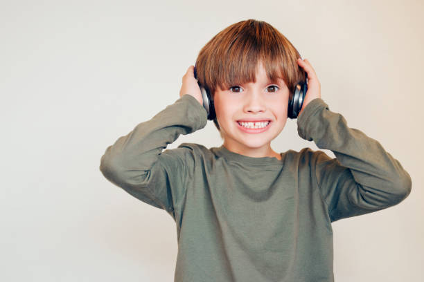 istock Studio shot of a cute little boy using headphones and posing against a wall 1367992473
