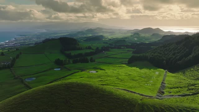 Magnificent nature of the Azores with green meadows, craters and the ocean. Aerial drone view from Miradouro do Pico do Carvão