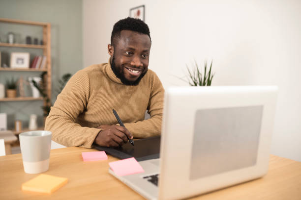 istock Young Afro designer freelancing from his home office 1367993017