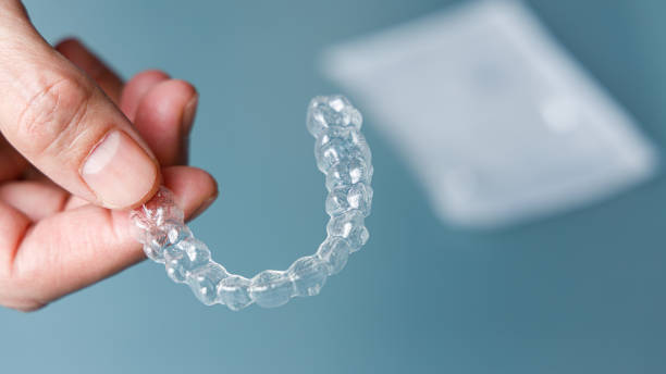 istock Hand holding one transparent aligner. Invisalign orthodontics concept 1367995434